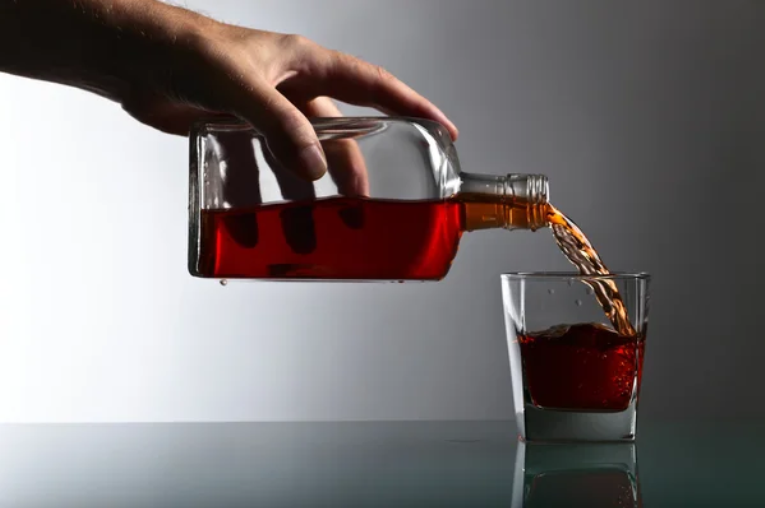 A man pouring alcohol in the glass