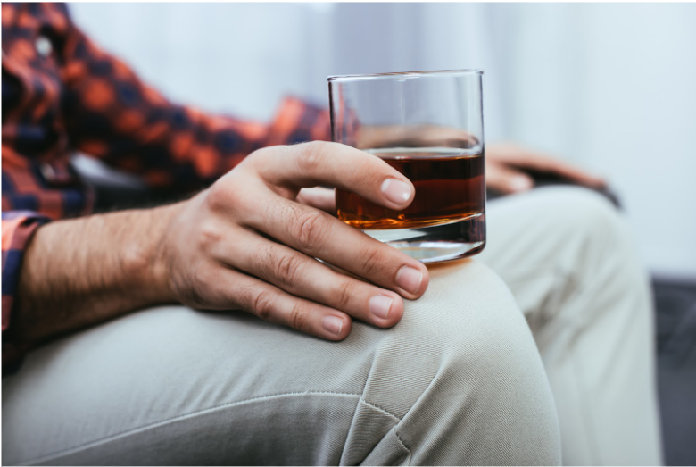 A man holding a glass of alcohol